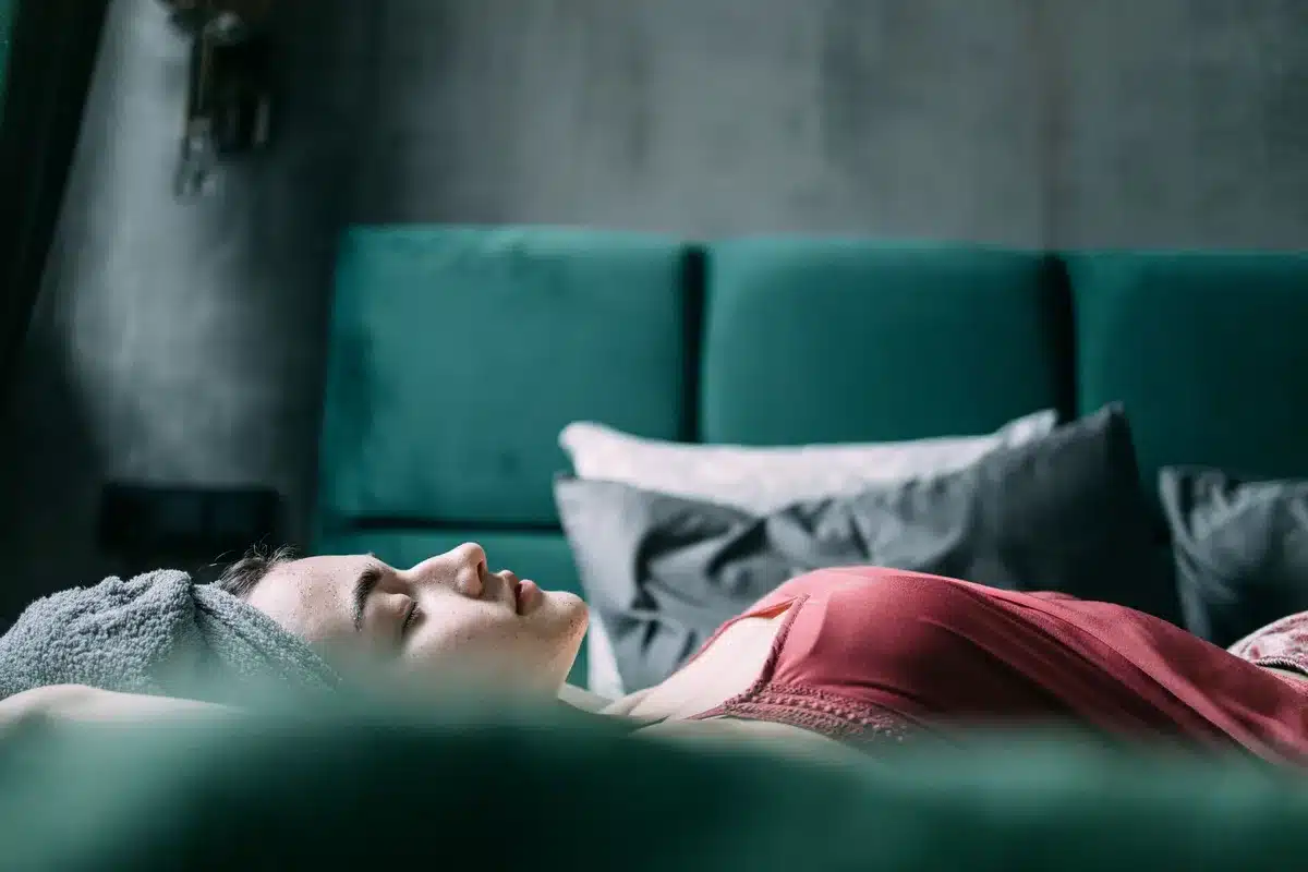 Personne dormant paisiblement dans un lit bien aéré avec lumière naturelle du matin