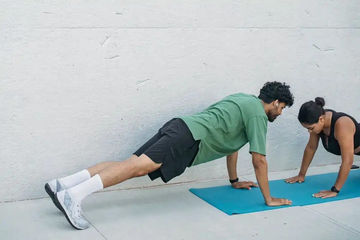 Personne en position de gainage (planche) sur un tapis d'exercice, corps aligné, dans un intérieur calme