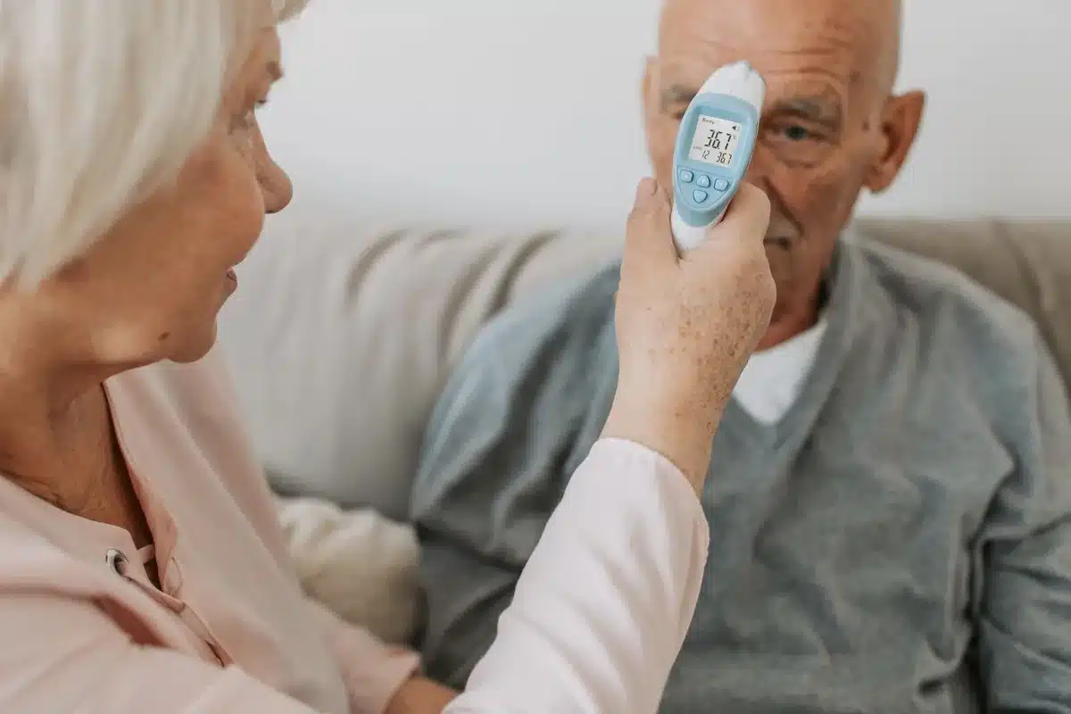 Personne âgée mesurant sa température corporelle pour surveiller sa santé