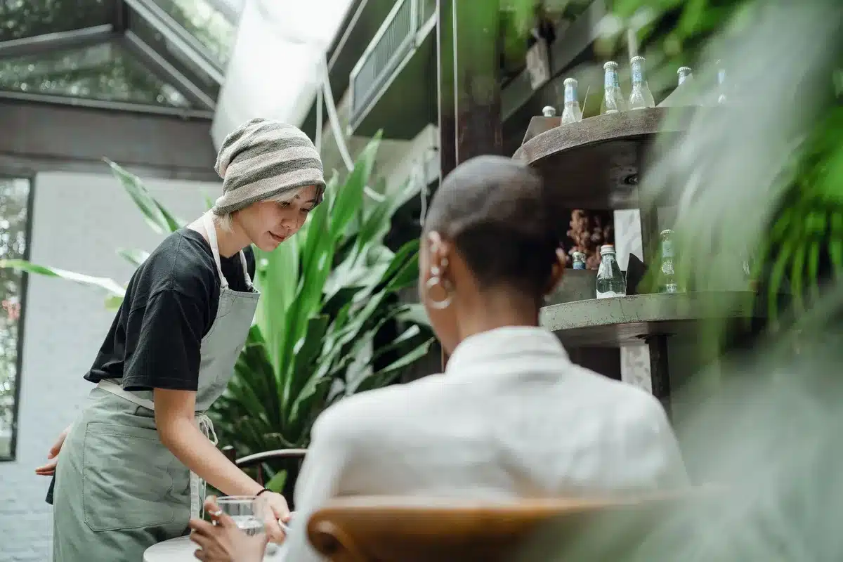 Client souriant montrant de l'empathie envers un serveur en restaurant