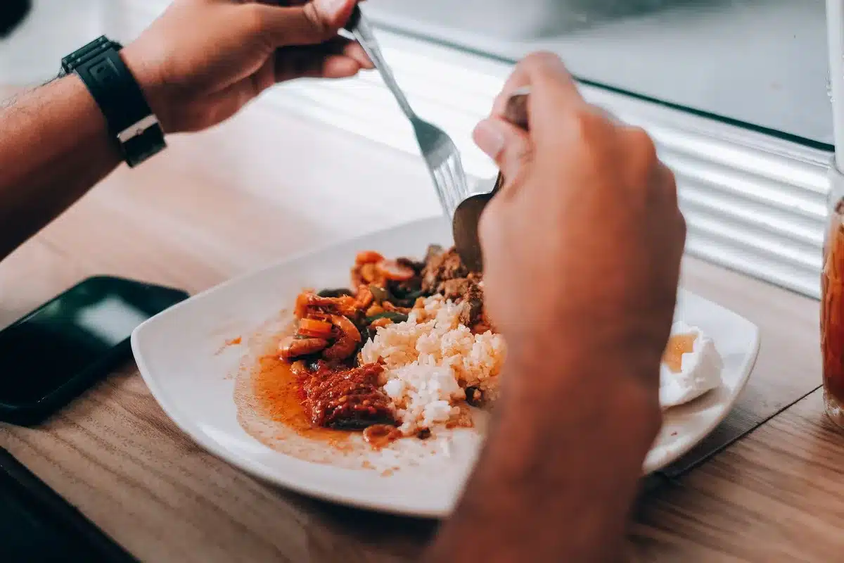 Mains de clients empilant les assiettes sur une table de restaurant
