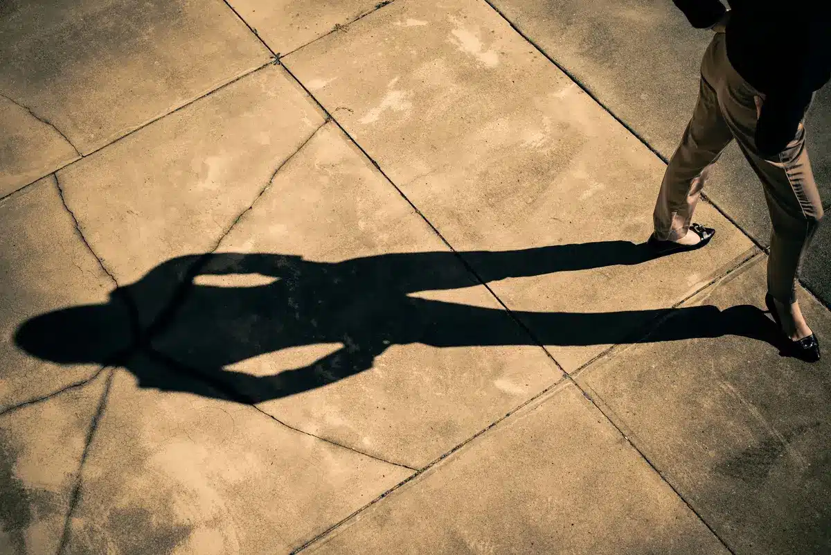 Personne marchant avec les mains derrière le dos, posture détendue et confiante