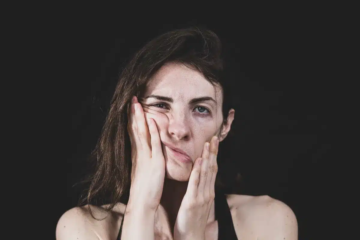 Détail des épaules et du visage d'une personne montrant l'expression faciale et la tension