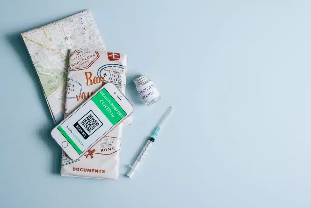 Carte de vaccination, passeport et documents de voyage sur un bureau avec seringue médicale