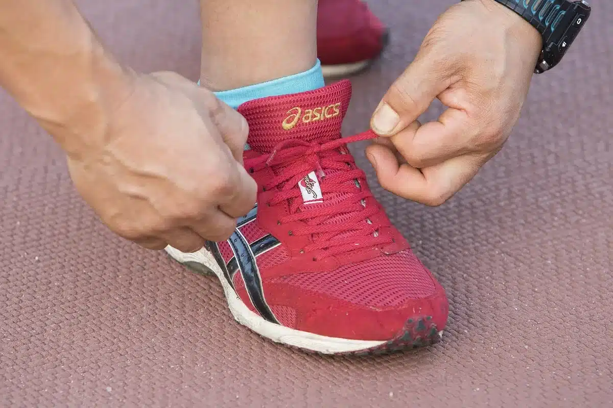 Paire de baskets génériques posée sur un banc de parc en plein jour montrant la semelle et le toe box