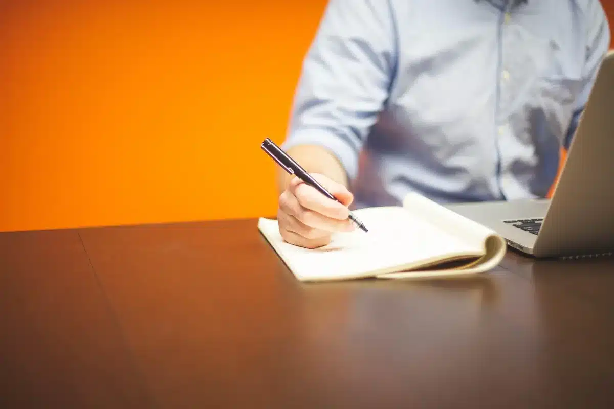 Personne travaillant sur un plan éditorial avec ordinateur et notes