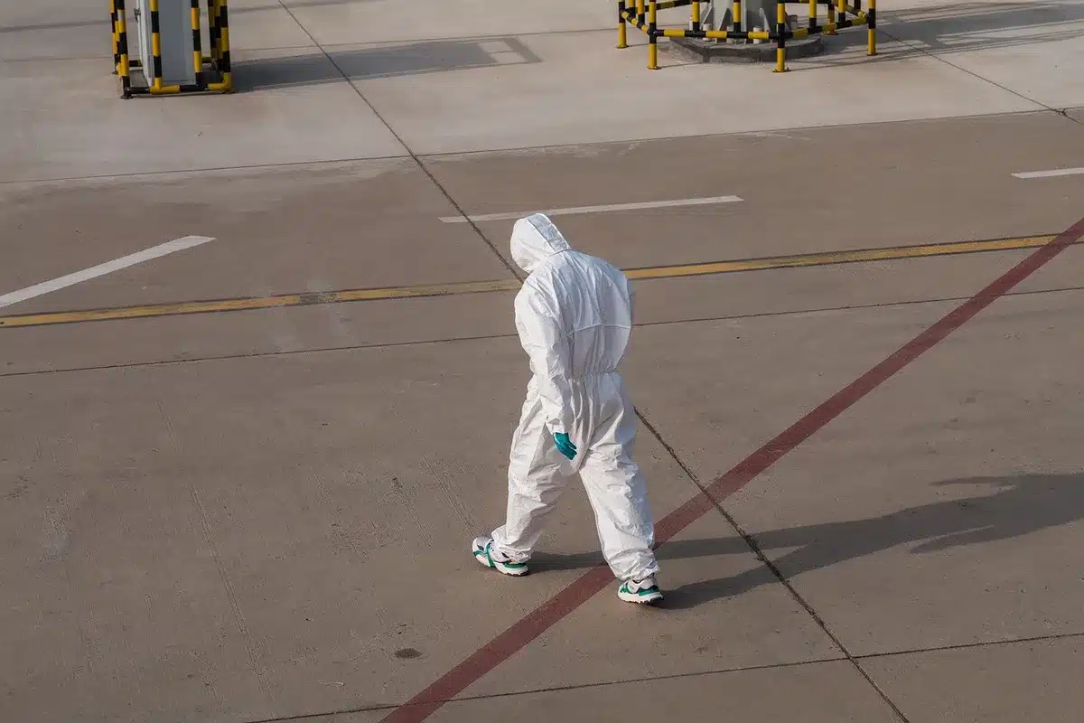 Professionnel de santé effectuant un dépistage médical à l'aéroport avec équipement de protection