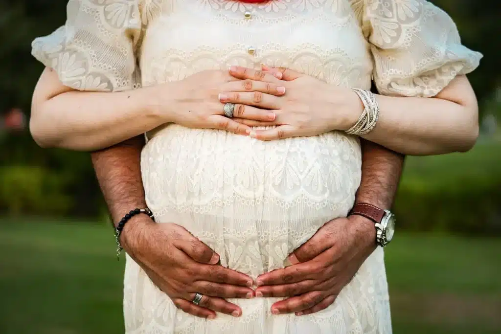 Silhouette d'une femme enceinte tenant son ventre avec les mains dans un environnement calme et intime