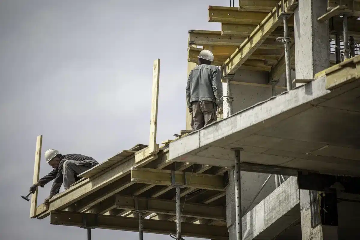 Équipe de construction travaillant sur un mur de briques en plein jour