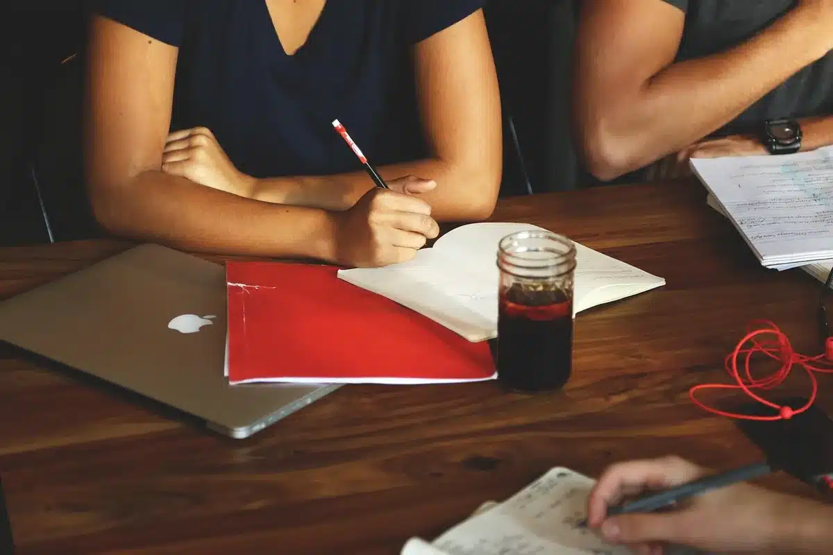 Équipe hospitalière discutant des commandes et de la gestion des stocks à une table ensoleillée